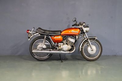 une moto posée par terre dans une pièce