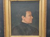 portrait of a man in a black shirt and a gold frame