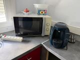a microwave and a coffee maker on the counter in the kitchen