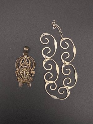 two pieces of jewelry are shown on a black surface
