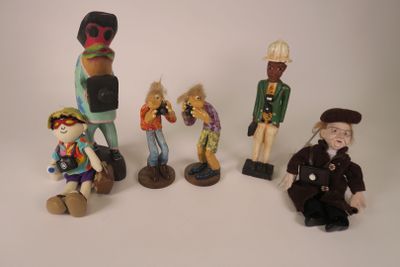 five figurines of different sizes and colors on a white surface