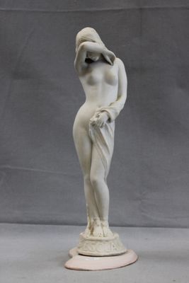 statue of a woman with a hat on her head and hands on her hips