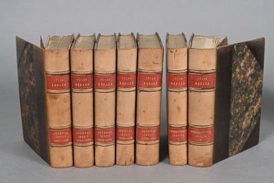 several old books are stacked on top of each other on a table