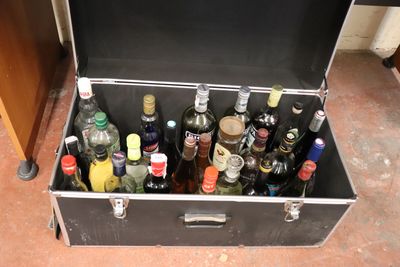 a trunk full of bottles of alcohol on the floor