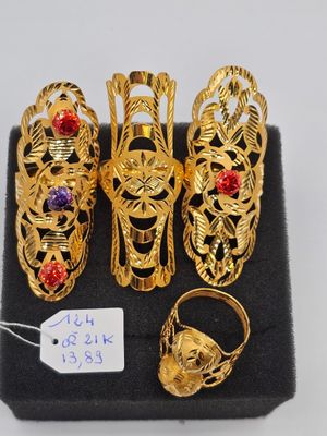 six paires de bagues et de bracelets en or, présentées dans un présentoir noir