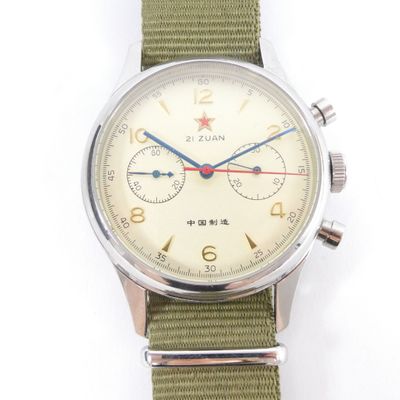 a close up of a wrist watch with a green strap