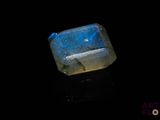 a close up of a blue stone on a black surface