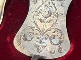 two silver hand held mirrors in a red velvet case