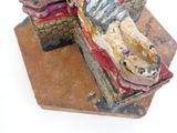 une figurine représentant un chat assis sur une boîte