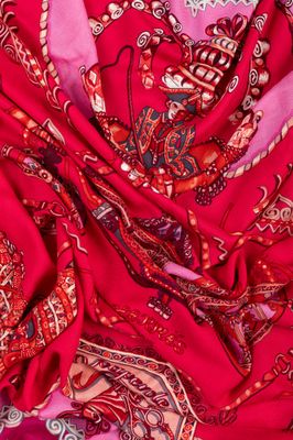 un gros plan sur une écharpe rouge et rose ornée de motifs paisley