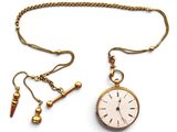 gold plated pocket watch with chain and earrings on a white background