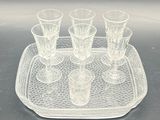 a tray with four glasses on it on a table