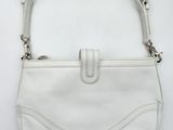 a white purse on a white surface with a strap