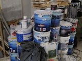 several buckets of paint are stacked on top of each other in a room