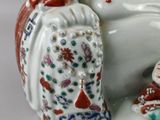 a figurine of a smiling buddha sitting on a chair