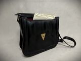 black leather purse with a gold triangle on the front and a white cloth inside