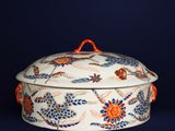 a white and orange bowl with a lid on a blue background