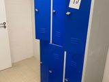 two blue lockers in a bathroom with a sign on the door