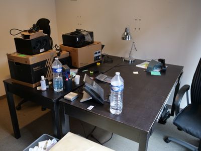 un bureau sur lequel se trouvent un téléphone, une bouteille d'eau et d'autres objets