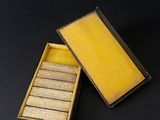 an open box with six small matches in it on a black surface