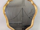 miroir doré en forme de coquille Saint-Jacques sur fond blanc, avec un pont en arrière-plan