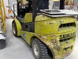 un chariot élévateur jaune garé à l'intérieur d'un bâtiment