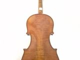 the back of a violin on a stand against a white wall