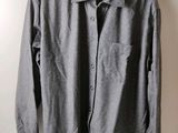 La chemise est suspendue à un cintre accroché au mur.