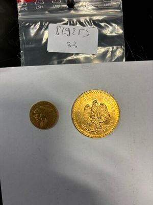 deux pièces d'or posées sur une feuille de papier, à côté d'une autre feuille de papier