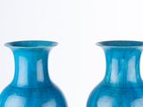 two blue vases sitting next to each other on a table