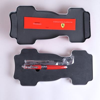 un stylo rouge dans un étui noir posé sur une surface blanche