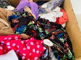 a cardboard box full of clothes and a teddy bear