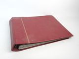 un vieux livre rouge dont deux pages sont ouvertes sur une surface blanche