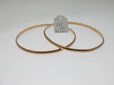 pair of gold tone bang bracelets with a price tag on a white background