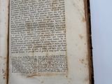 an old book open on top of a white table