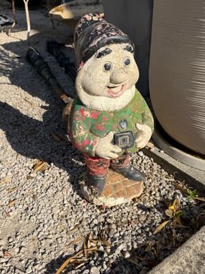 a statue of a snowman holding a camera on the ground