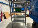 a close up of a metal shelf in a warehouse with a blue van in the background