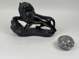 a statue of a lion sitting on a rock next to a crystal ball