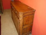 a wooden dresser in the corner of a room