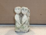 une sculpture en pierre représentant deux personnes se tenant la main, allongées par terre