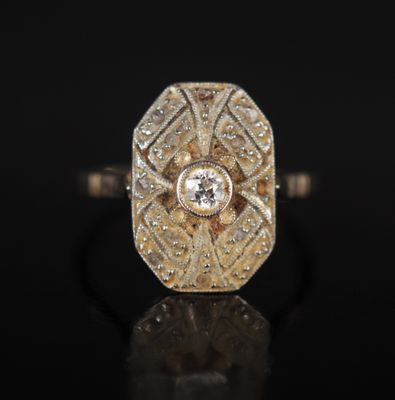 une bague en or et diamants sur une surface noire