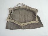 an old silver mesh purse with a chain hanging from it ' s side
