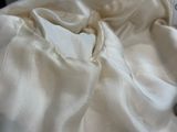 une télécommande posée sur un lit blanc