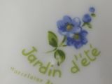 a close up of a plate with a blue flower on it