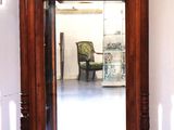 un miroir posé sur le sol à côté d'une chaise