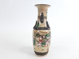 un vase orné d'une peinture posé sur une surface blanche