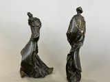 pair of bronze figurines of a woman and a man