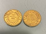 two pieces of gold coins sitting on top of a table