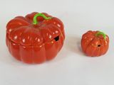 two small plastic pumpkins sitting next to each other on a white surface