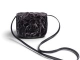 Le petit sac noir est orné d'une fleur sur le devant.